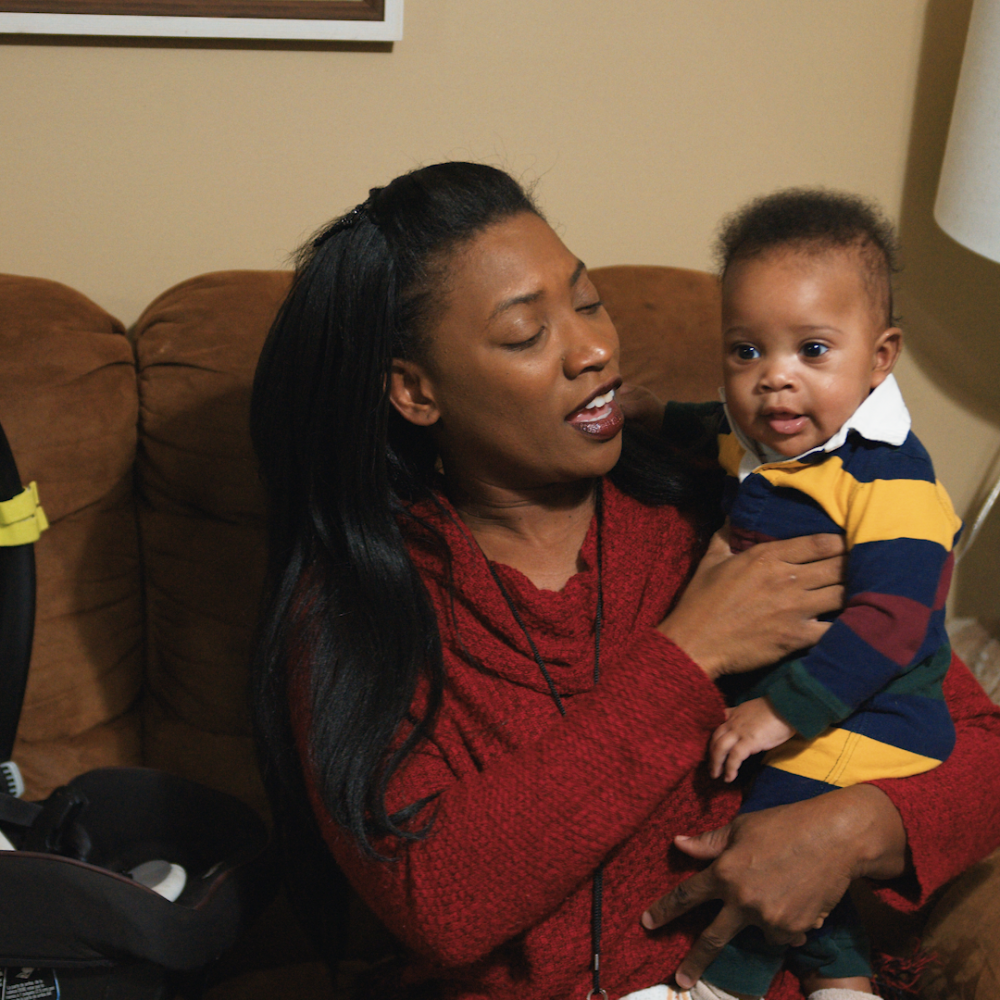 A young mother holds her infant son. 