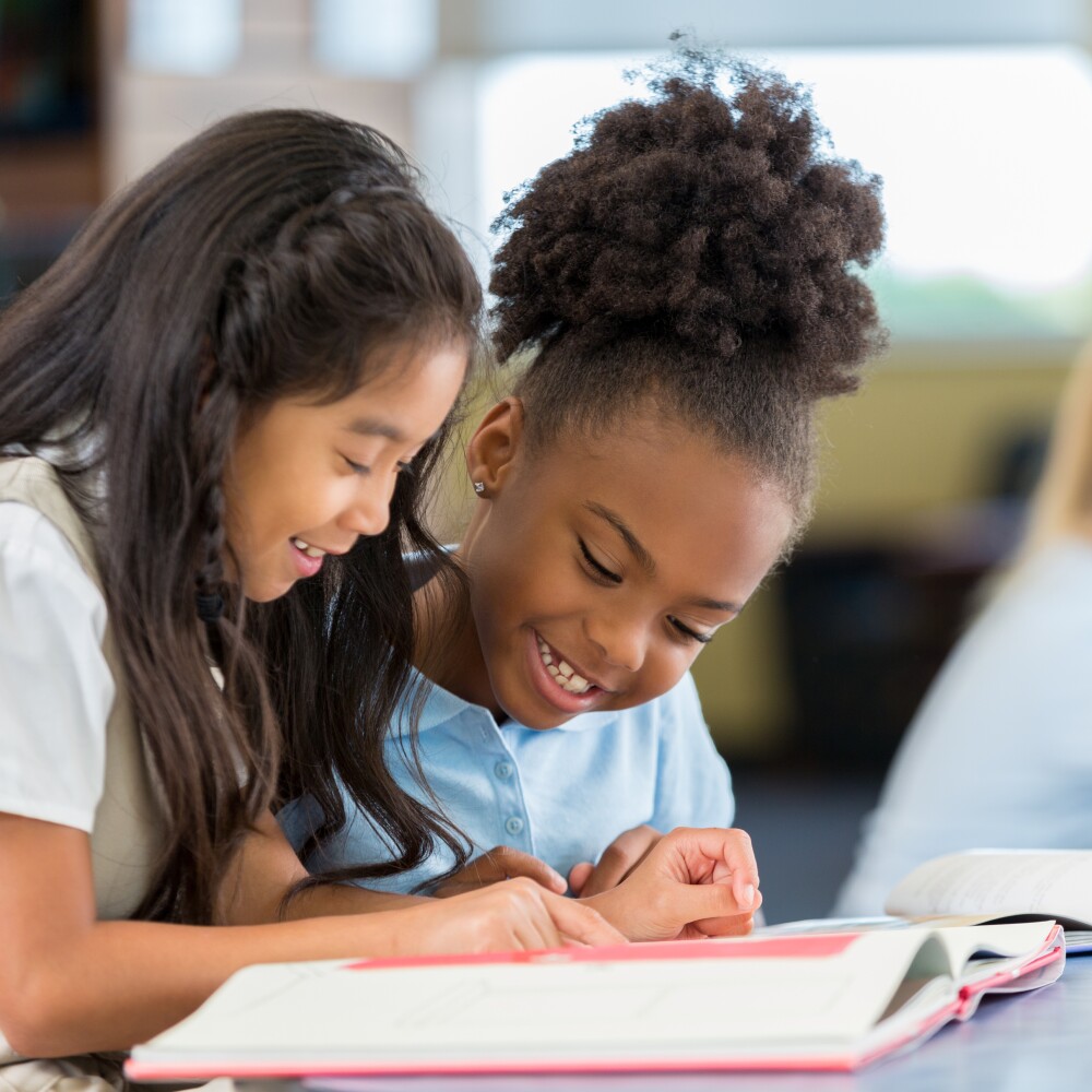 Two female students reading in a classroom