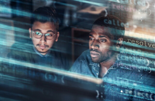 Two computer programmer work in an office superimposed over multiple lines of code.