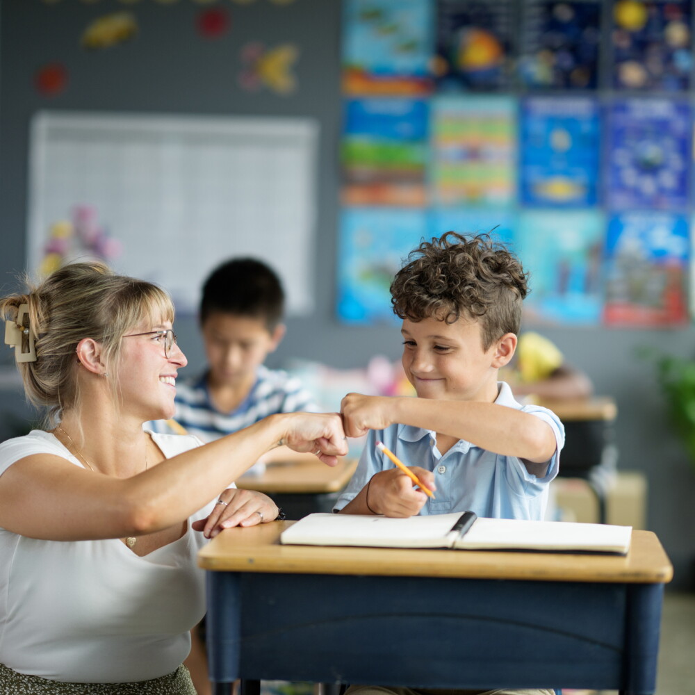 Teacher fist bumps student