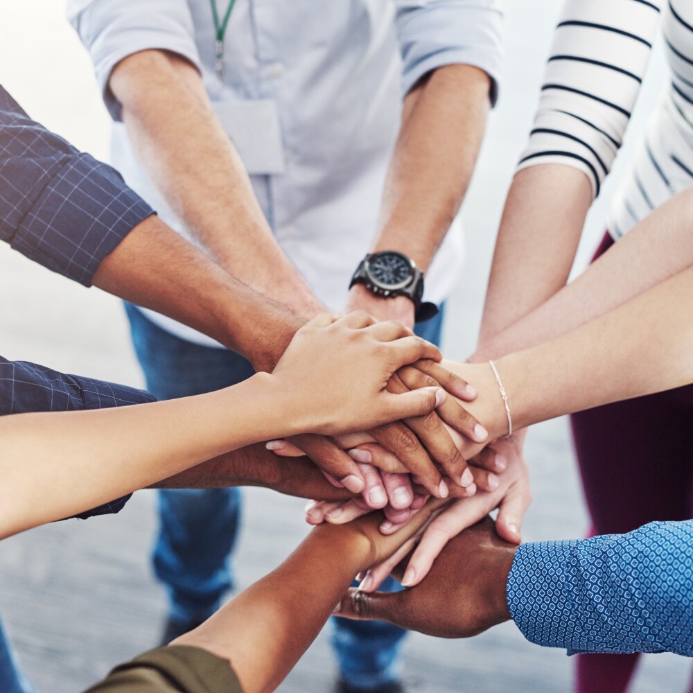 Diverse group of hands clasped