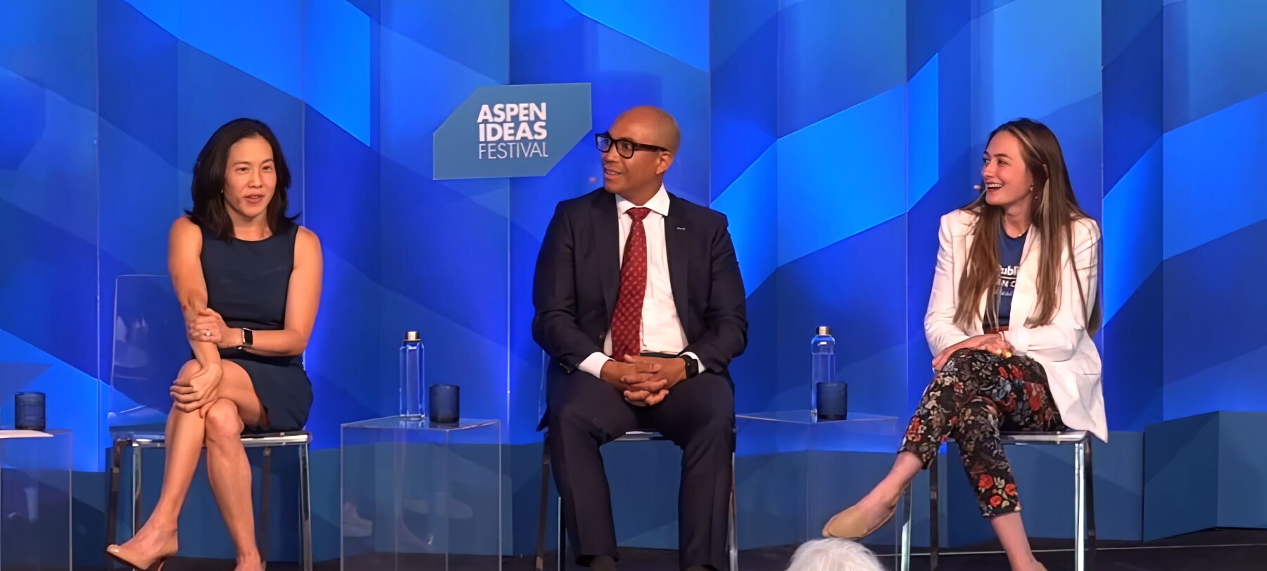 Two women and a man sit onstage at a panel at the Aspen Ideas Festival. 