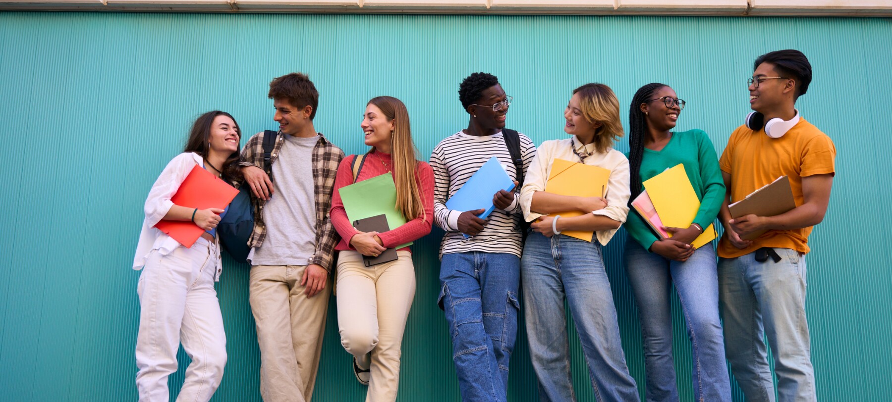 A group of young Gen Z students stand in a line. 