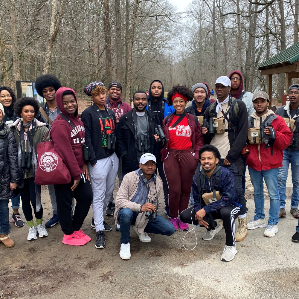 A group of college students poses for a photo before going birdwatching.