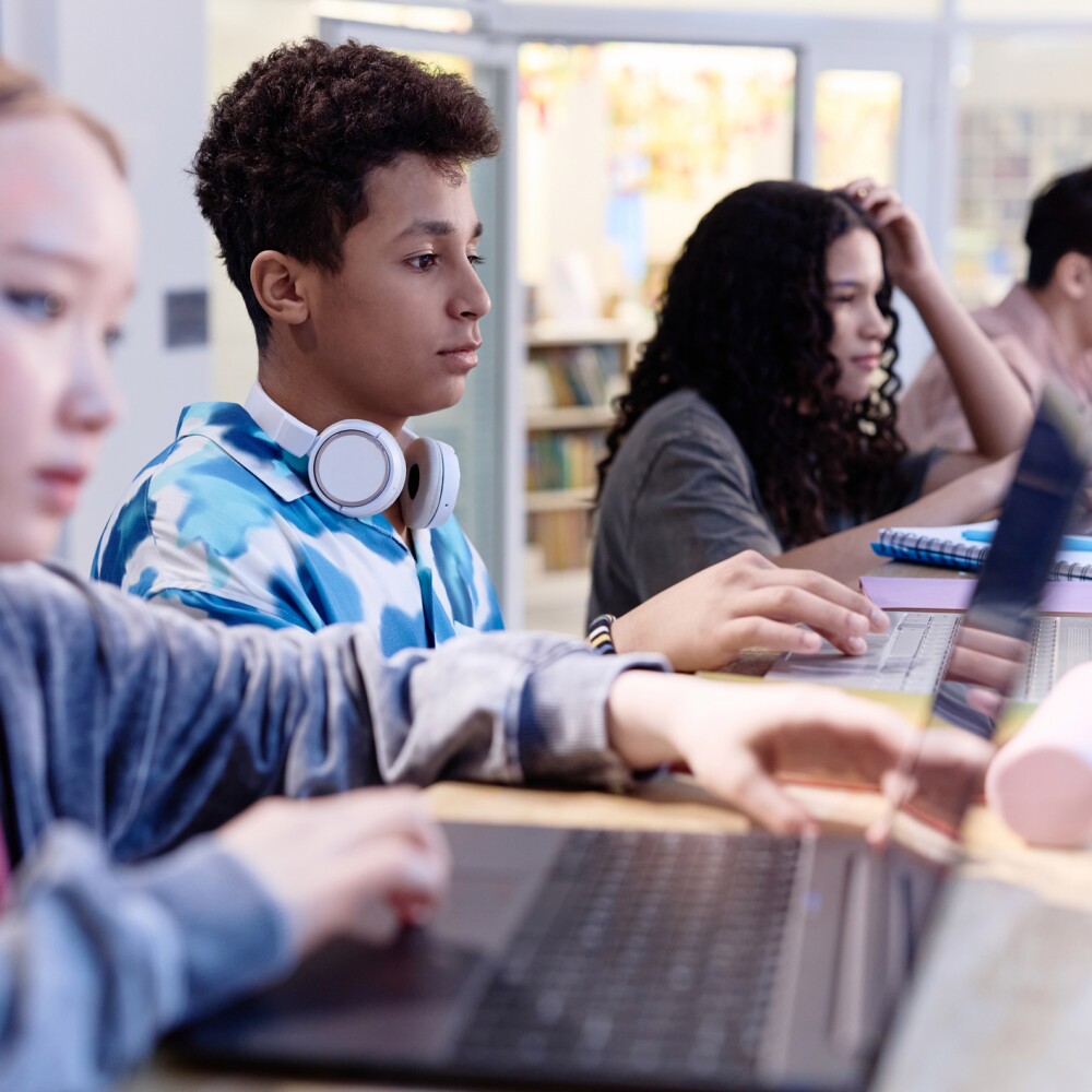 Middle Eastern Boy using Computer in Library in Row