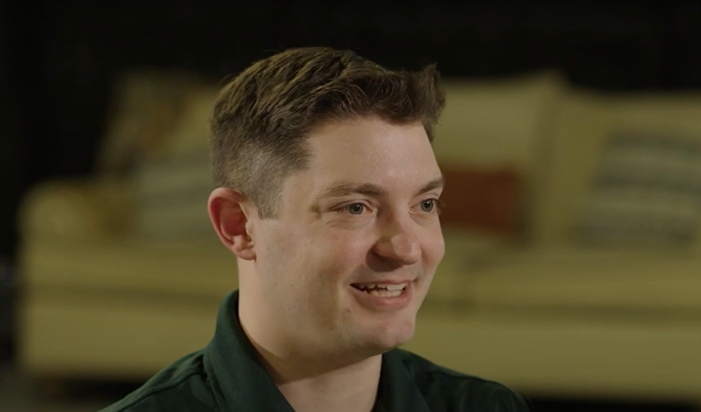 Photo of a man smiling during a video interview. 