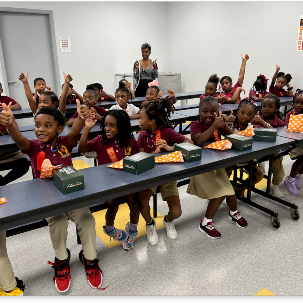 Students give a thumbs up after receiving awards for perfect attendance.