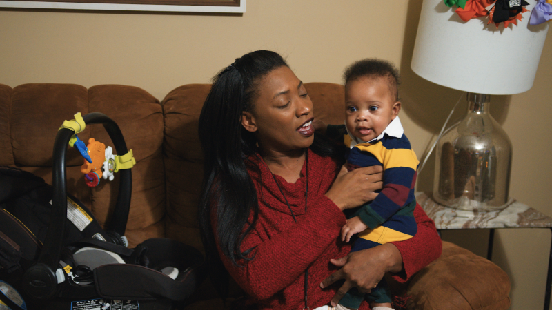 A young mother holds her infant son. 