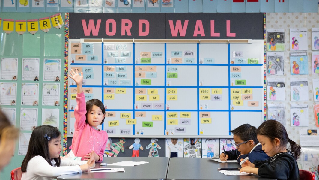 Kindergarten girl raises hand