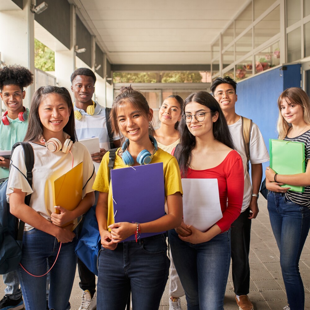 Group of students holding notebooks smiling