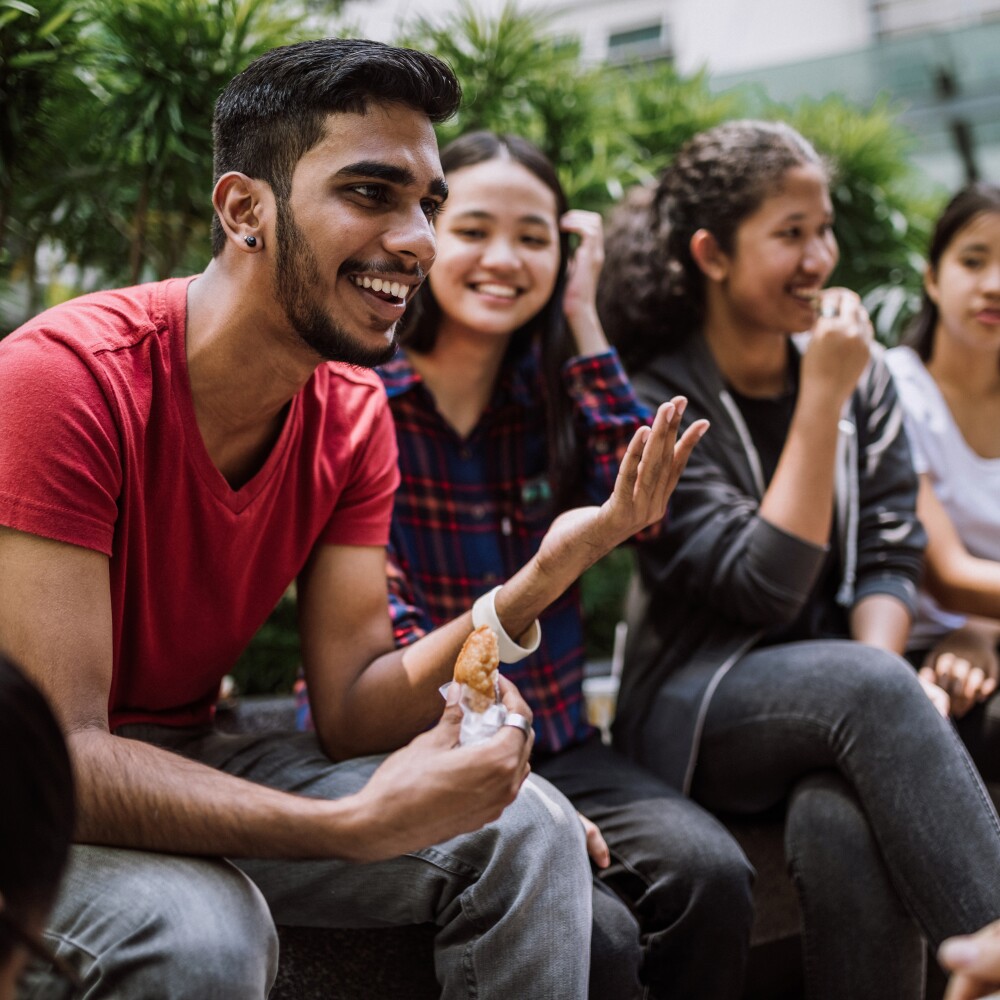 A group of culturally diverse students share laughter and conversation.