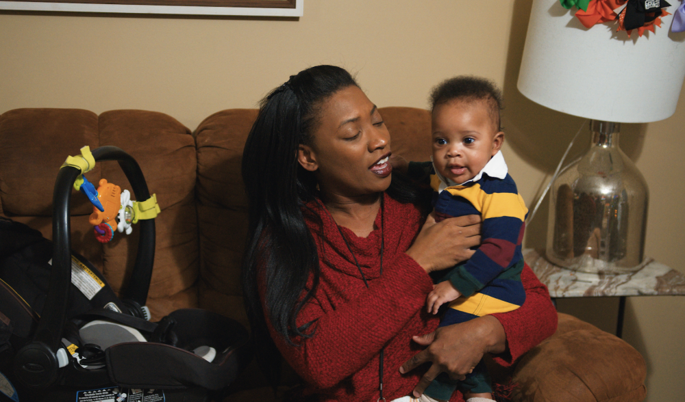 A young mother holds her infant son. 