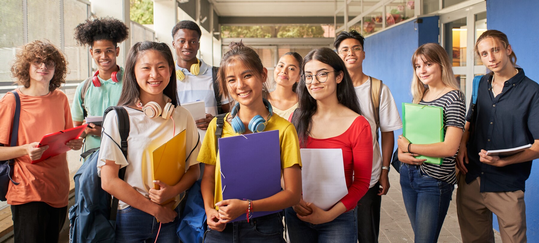 Group of students holding notebooks smiling