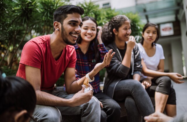 A group of culturally diverse students share laughter and conversation.