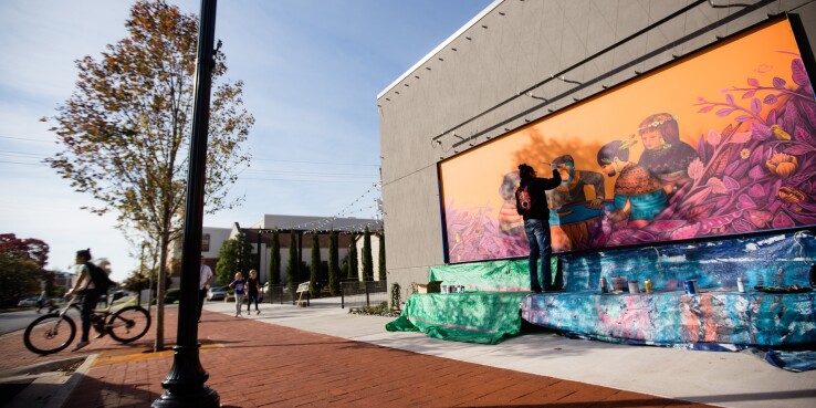 Artist painting a mural in Bentonville