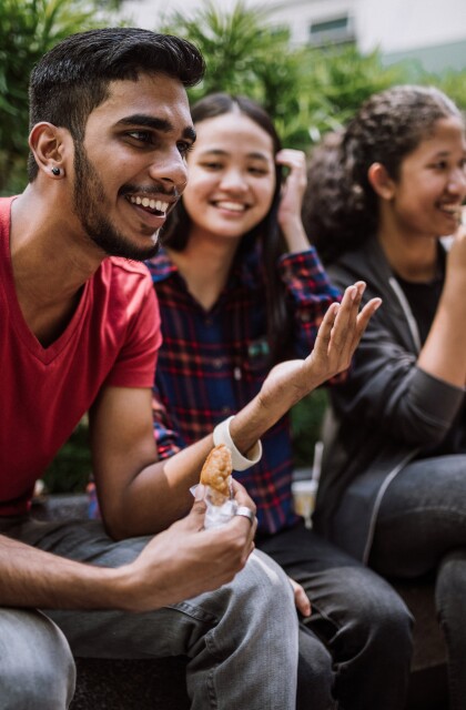 A group of culturally diverse students share laughter and conversation.
