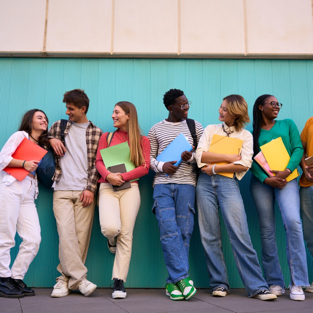 A group of young Gen Z students stand in a line. 