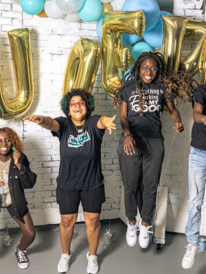 A group of young people jump in celebration. 
