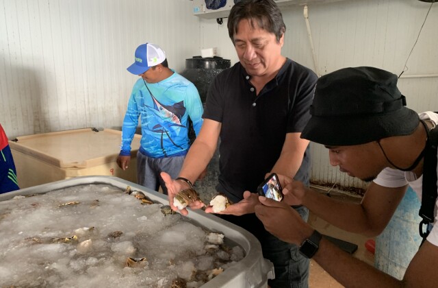 José Luis “Chino” Carrillo shows Walton Family Foundation intern Joshua Ventress some of the day's catch